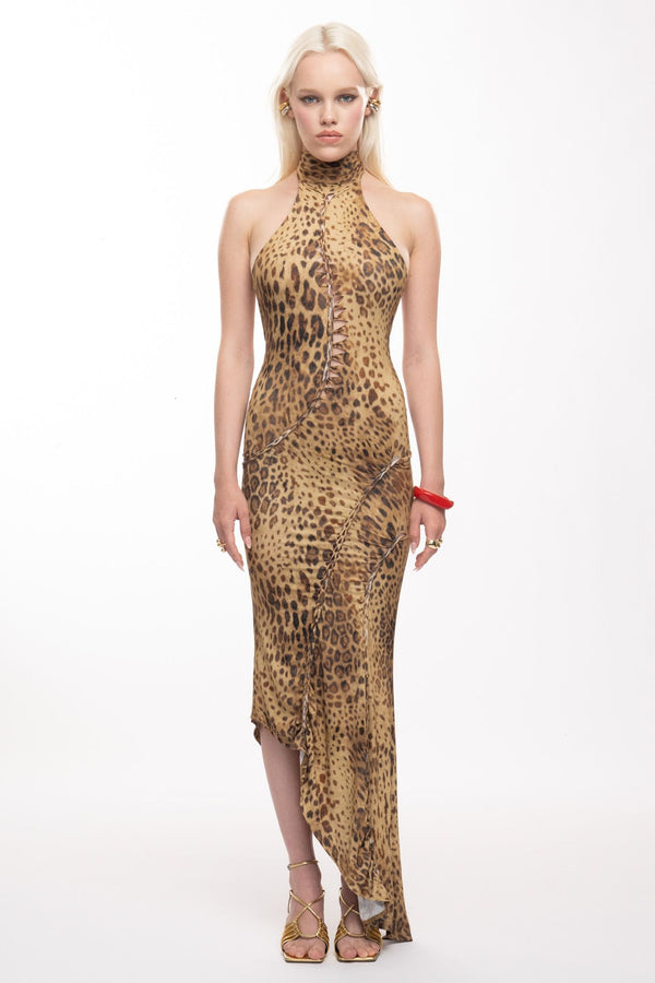 Model wearing the Senja Dress, a leopard print halter maxi dress with asymmetric hem