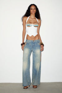 Model wearing the Regan Jeans, baggy low-rise light wash jeans, with a white corset top